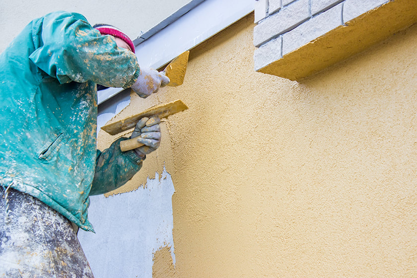 technician completing water damaged stucco repair in Palm Bay, FL.